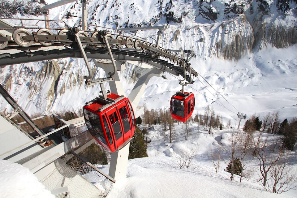 A cable car system in a snowy mountainous area.