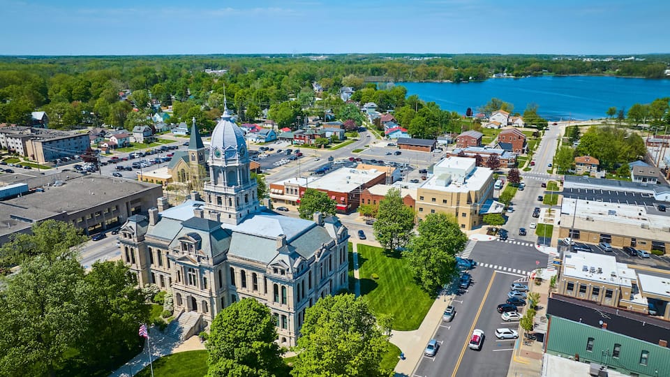 A town with a prominent church, a lake, and surrounding greenery.