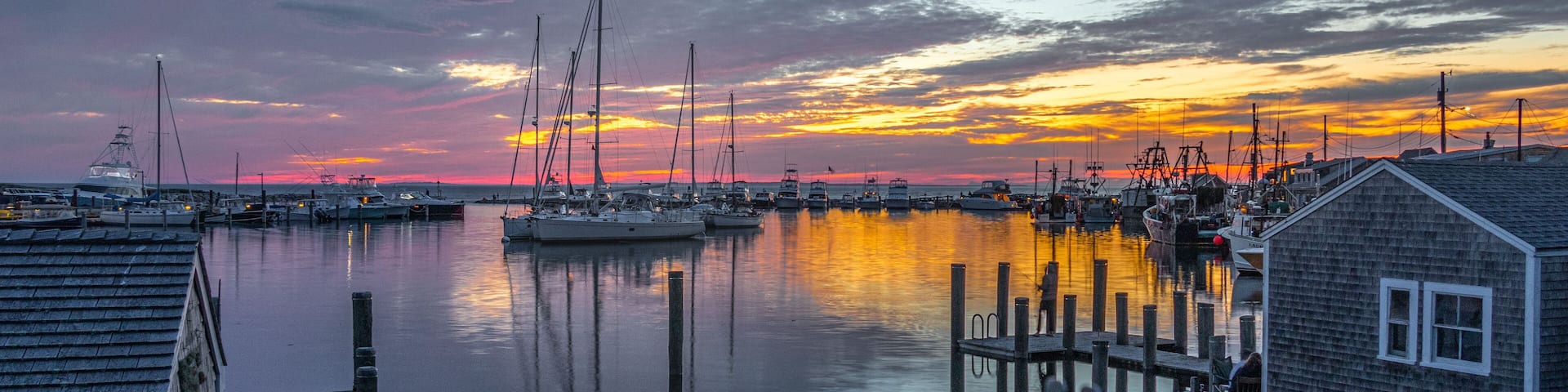A marina with boats docked at sunset.