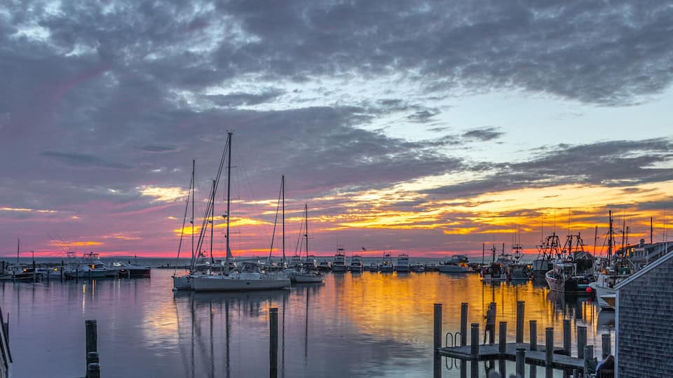 A marina with boats docked at sunset.
