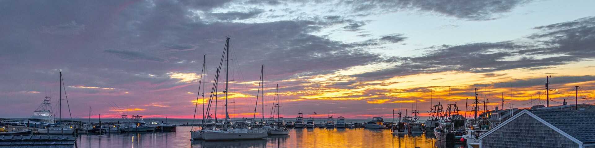 Un puerto deportivo con barcos amarrados al atardecer.