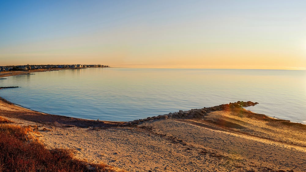 Sunrise over the Horizon and Beach Cove on Cape Cod, Massachusetts, a tranquil seascape of Falmouth Shoreline with a view of Martha's Vineyard in Atlantic Ocean