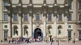 A historic building with classical architecture, featuring columns, statues, and an ornate entrance.