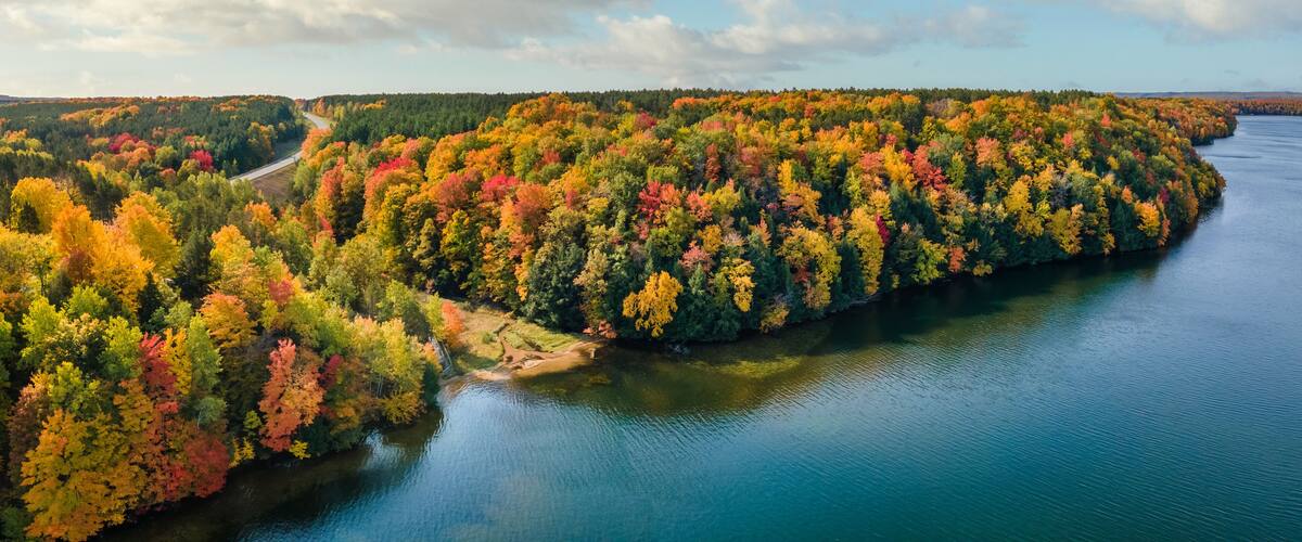 A river winding through a forest with autumn foliage.