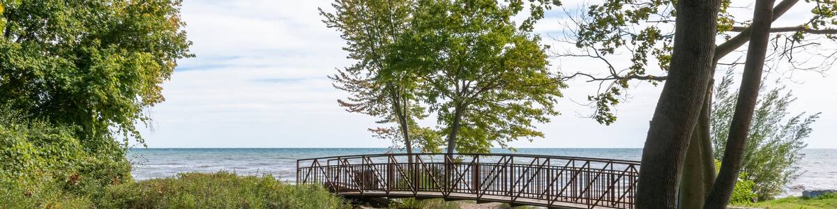 A footbridge crosses a small stream flowing into Lake Erie in the former pioneer town of Normandale, Ontario, now primarily a cottage town.