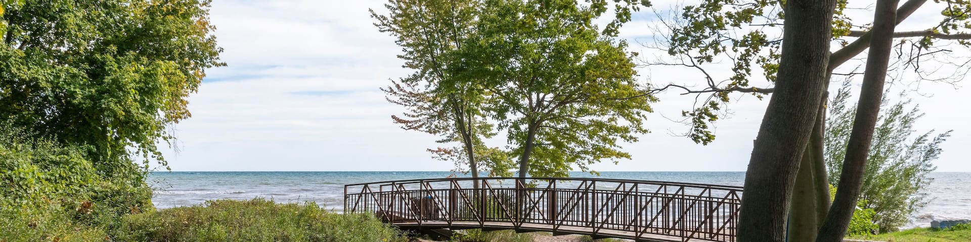A footbridge crosses a small stream flowing into Lake Erie in the former pioneer town of Normandale, Ontario, now primarily a cottage town.