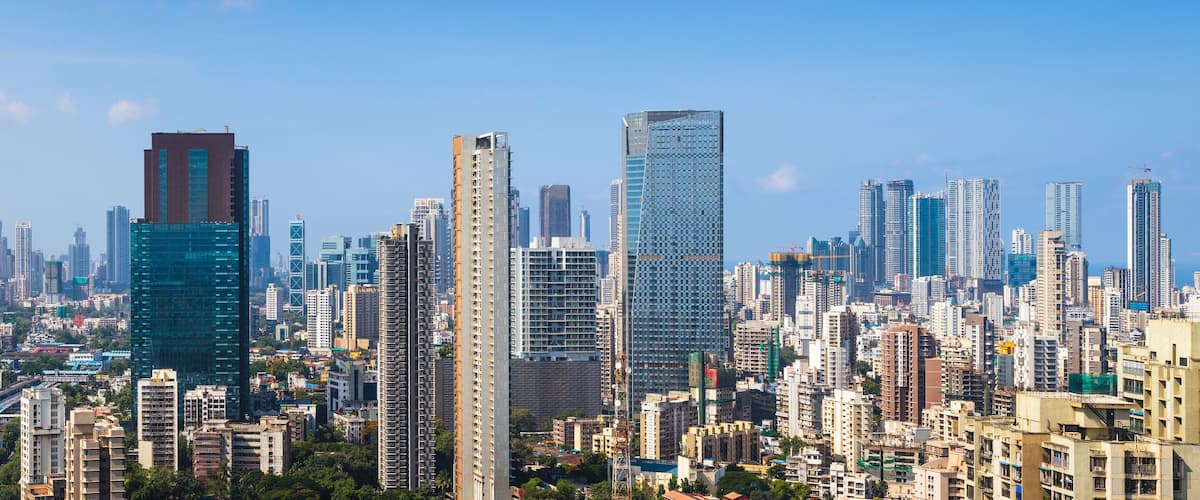 A densely packed urban skyline with numerous high-rise buildings and a network of train tracks.