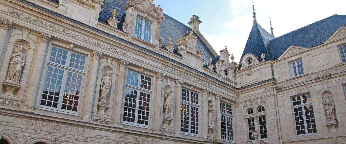 A historic building with ornate architecture, including statues and detailed carvings.