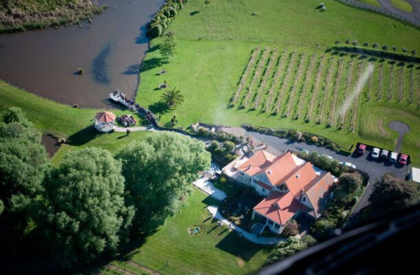 An aerial view of a property with a large house, a pond, and a well-maintained lawn.