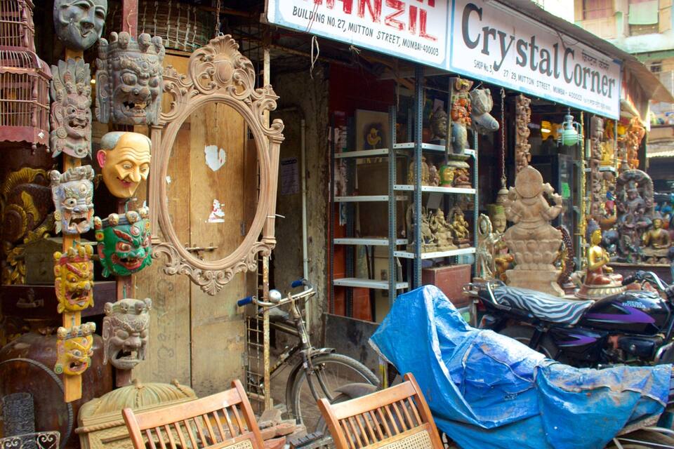 A shop with a sign reading "Crystal Corner" and various statues and masks displayed outside.