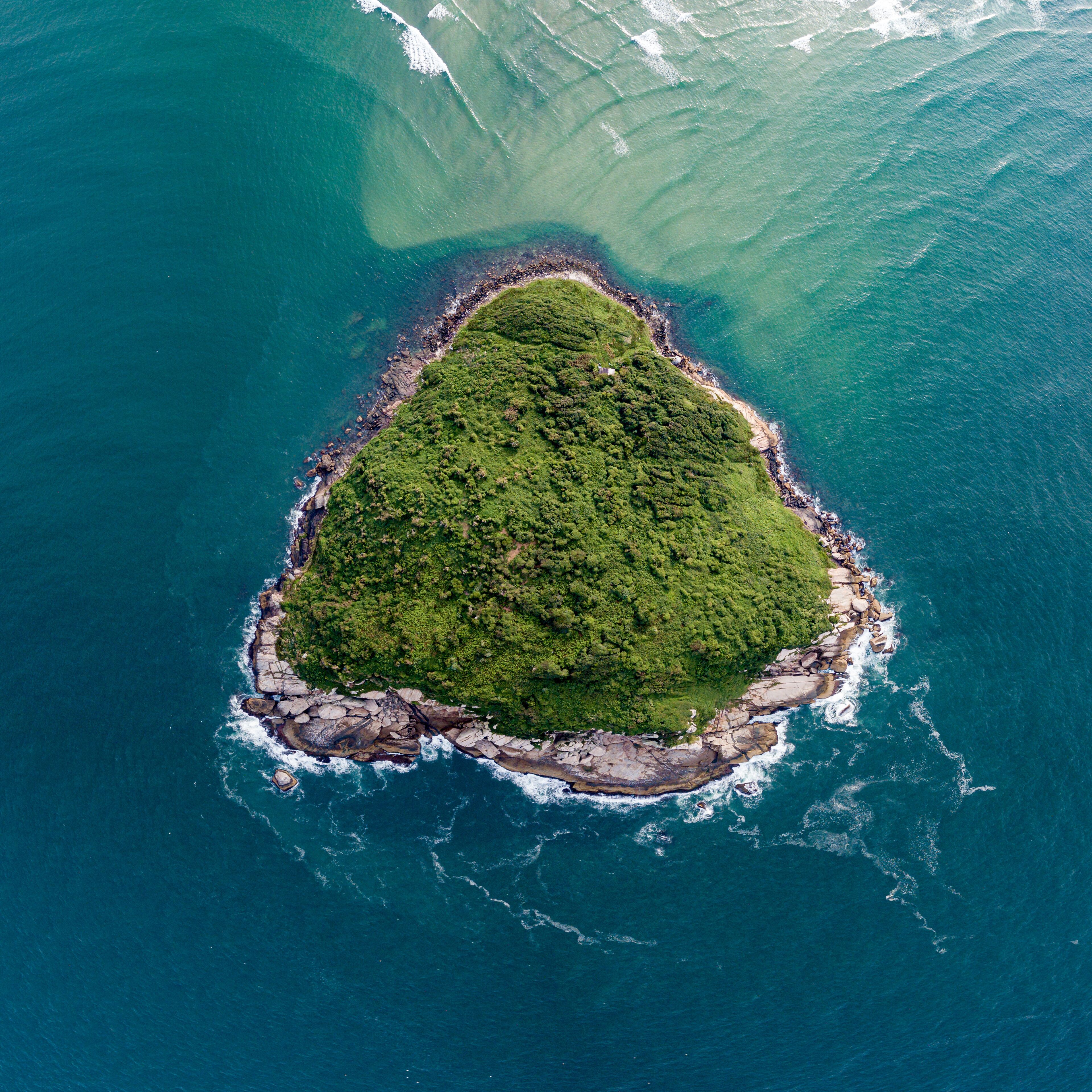 Aerial view of a triangular-shaped island in green sea