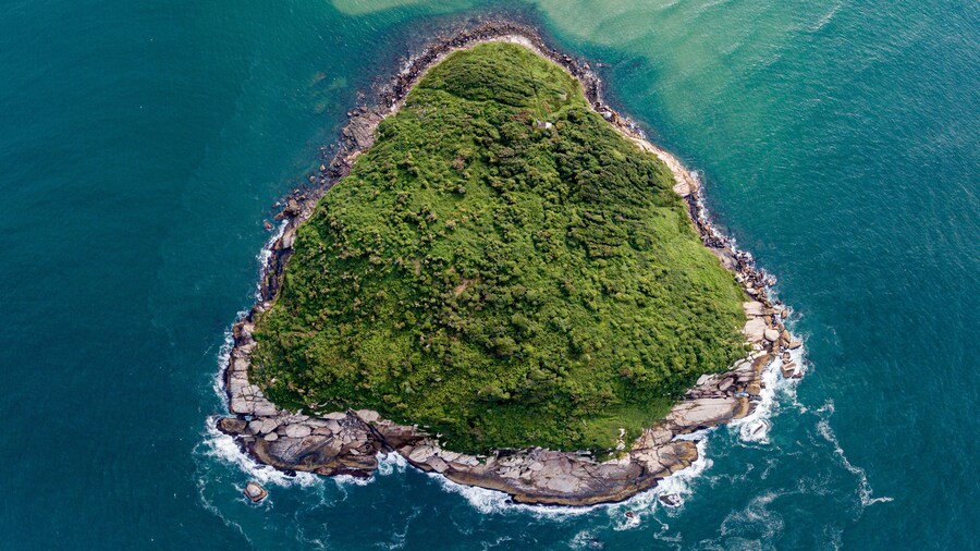 Aerial view of a triangular-shaped island in green sea