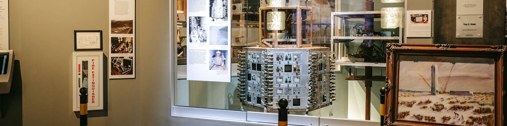 Una exposición con equipos científicos, obras de arte enmarcadas y paneles informativos.