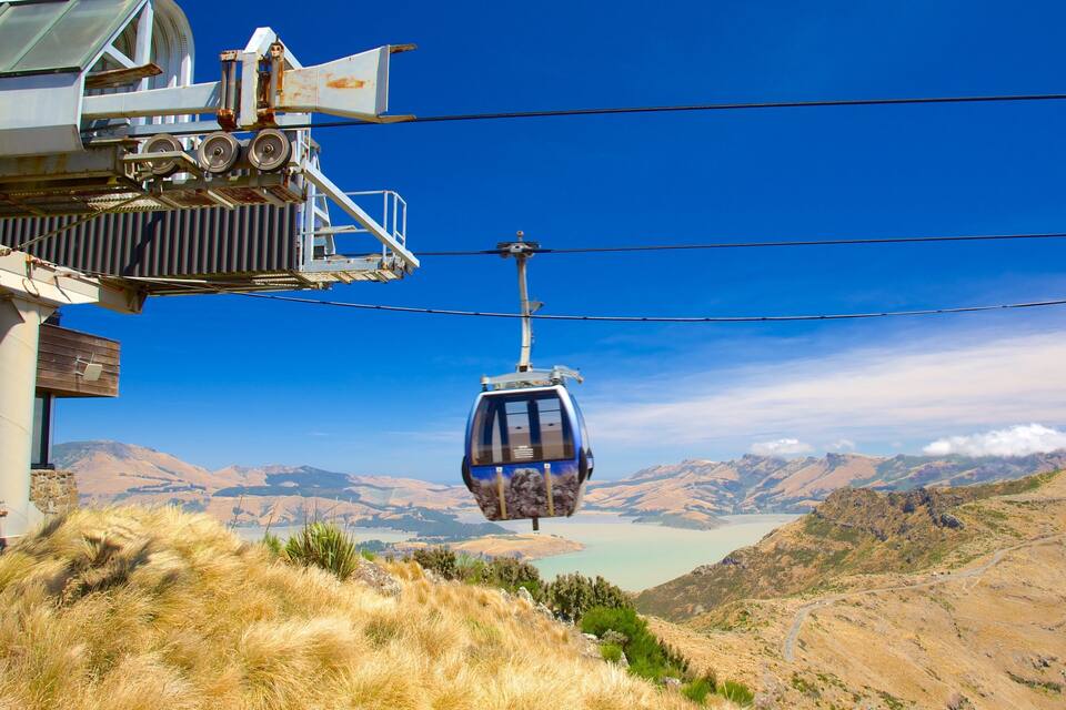 Un teleférico suspendido sobre un paisaje montañoso con cielo despejado.