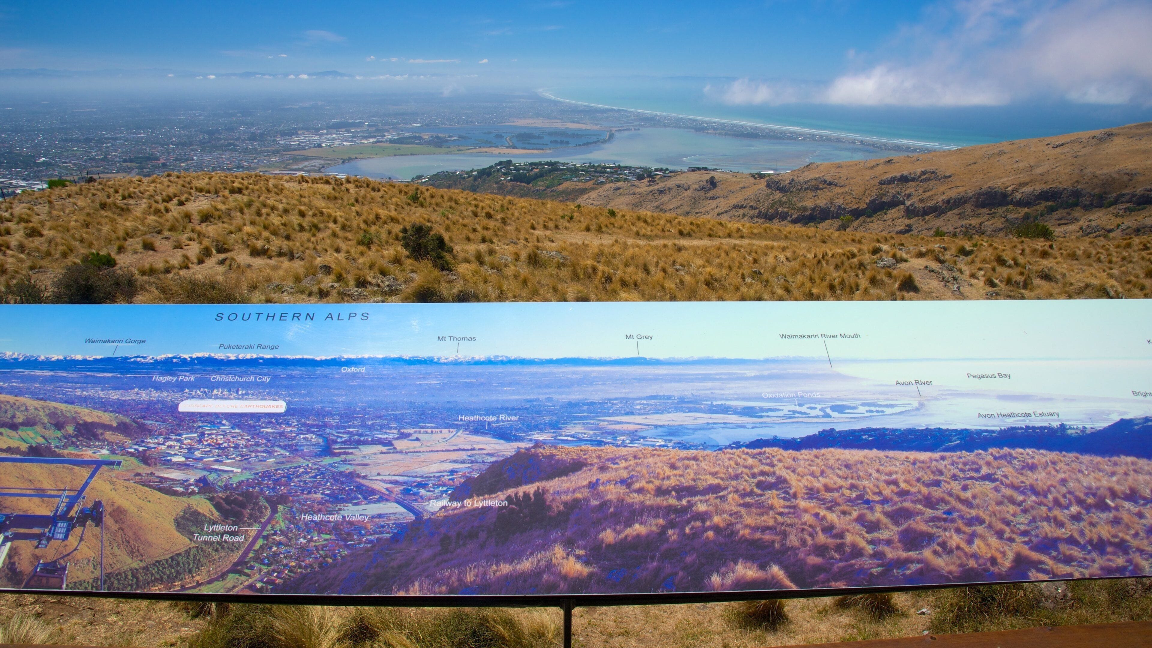 Paisagem costeira com praia, colinas e um rio.