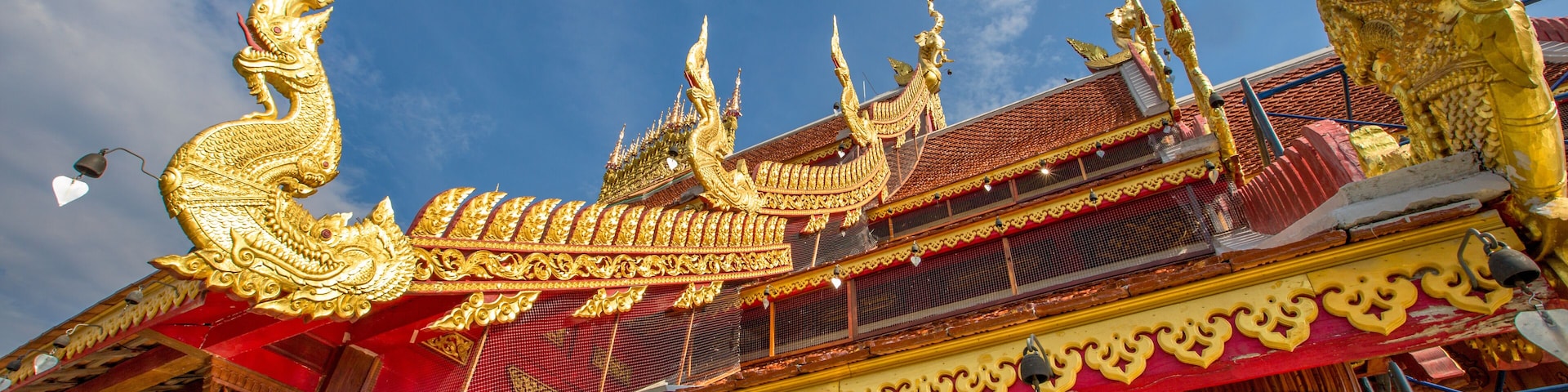 Um templo dourado e ornamentado com esculturas detalhadas e um telhado vermelho.