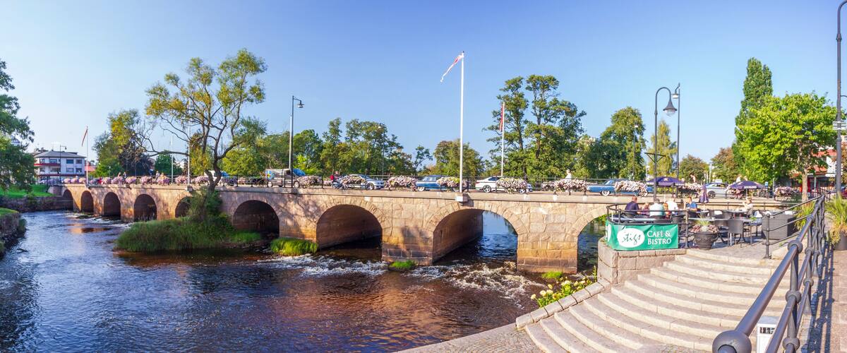 A stone bridge over a river with cars and pedestrians.