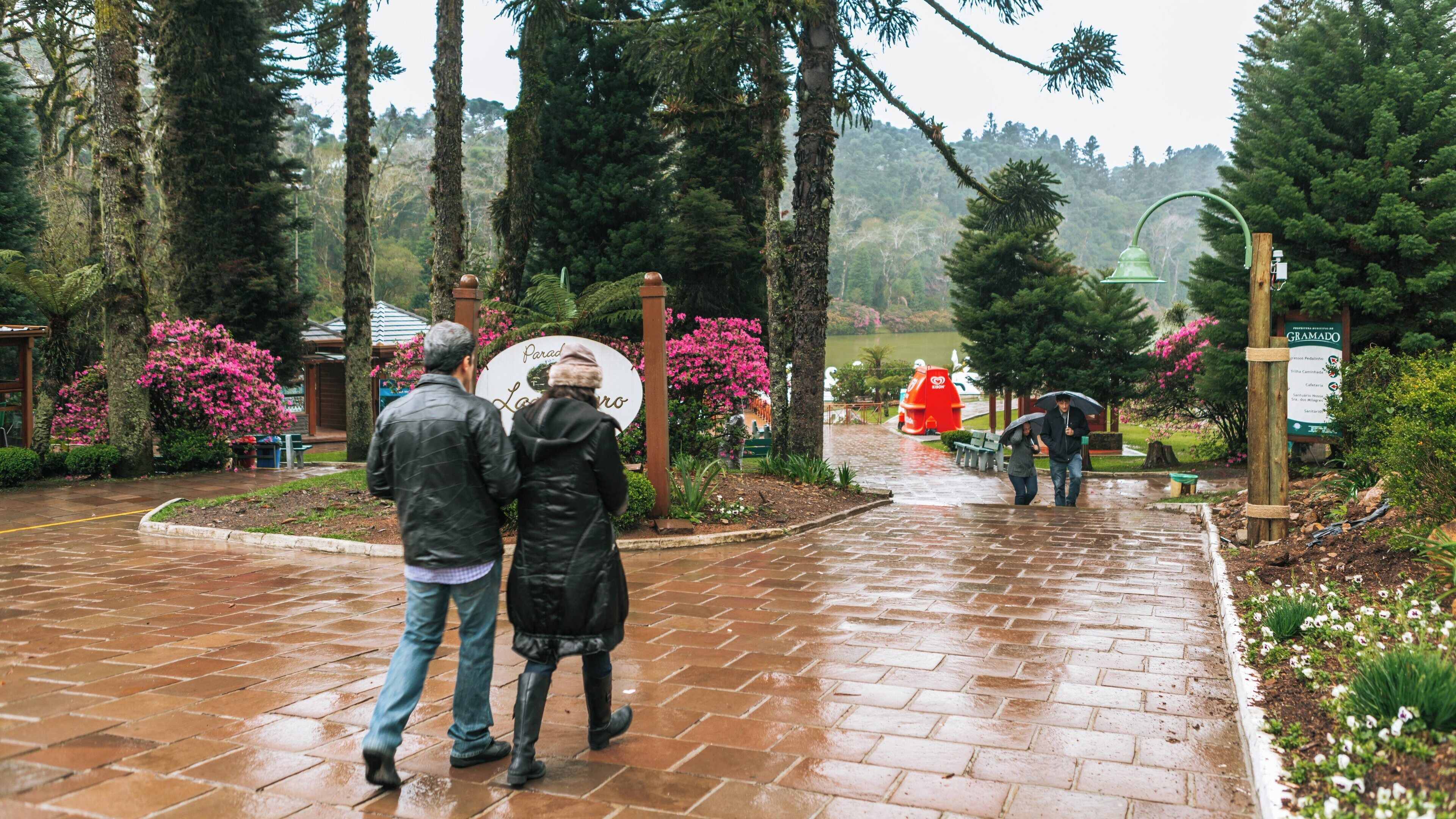 Couple strolling through Black Lake Park in Três Pinheiros, Gramado, Rio Grande do Sul, Brazil on a rainy day