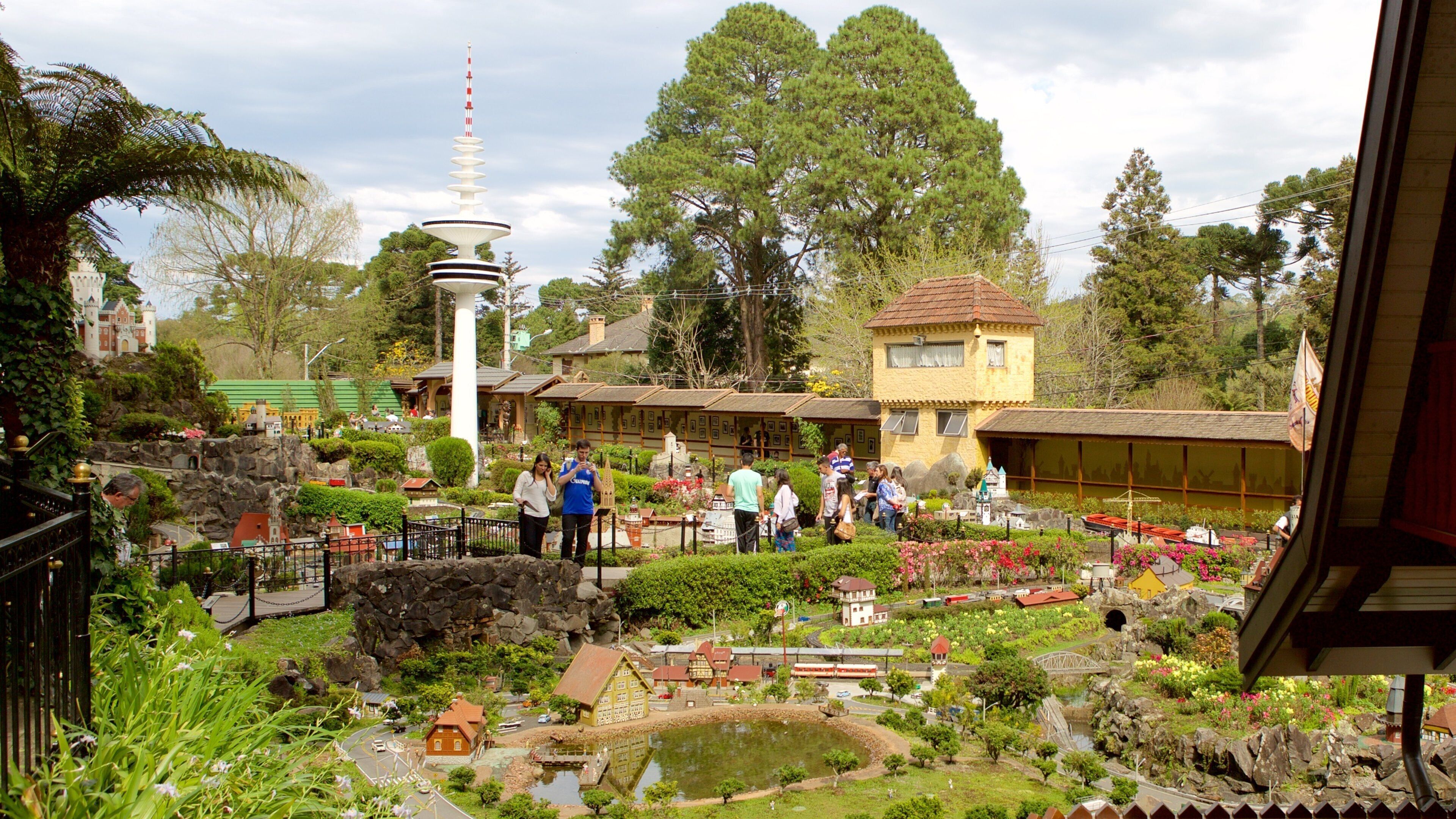 A model village with miniature buildings, a tower, and a pond.