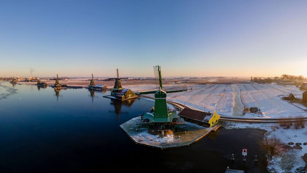 panoramic view over the Zaanse Schans windmill village snow covered during winter, Zaanse Schans wind mills historical wooden mills in the Netherlands. Europe