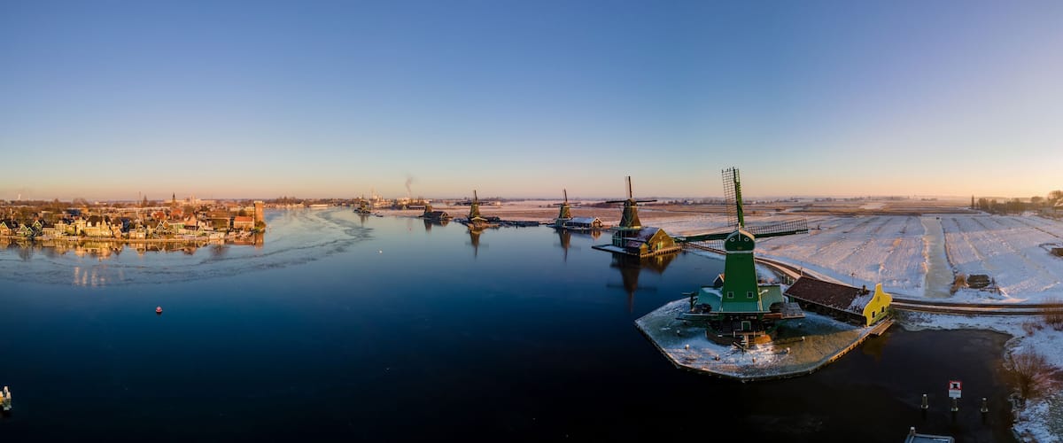 panoramic view over the Zaanse Schans windmill village snow covered during winter, Zaanse Schans wind mills historical wooden mills in the Netherlands. Europe