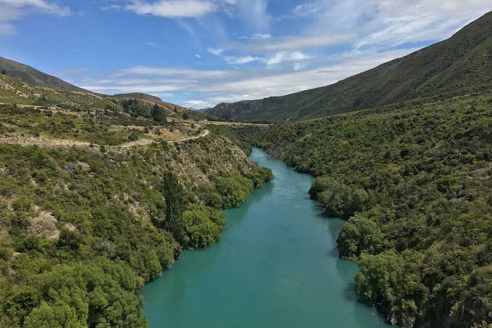 Un río serpentea por un paisaje montañoso con densa vegetación verde.