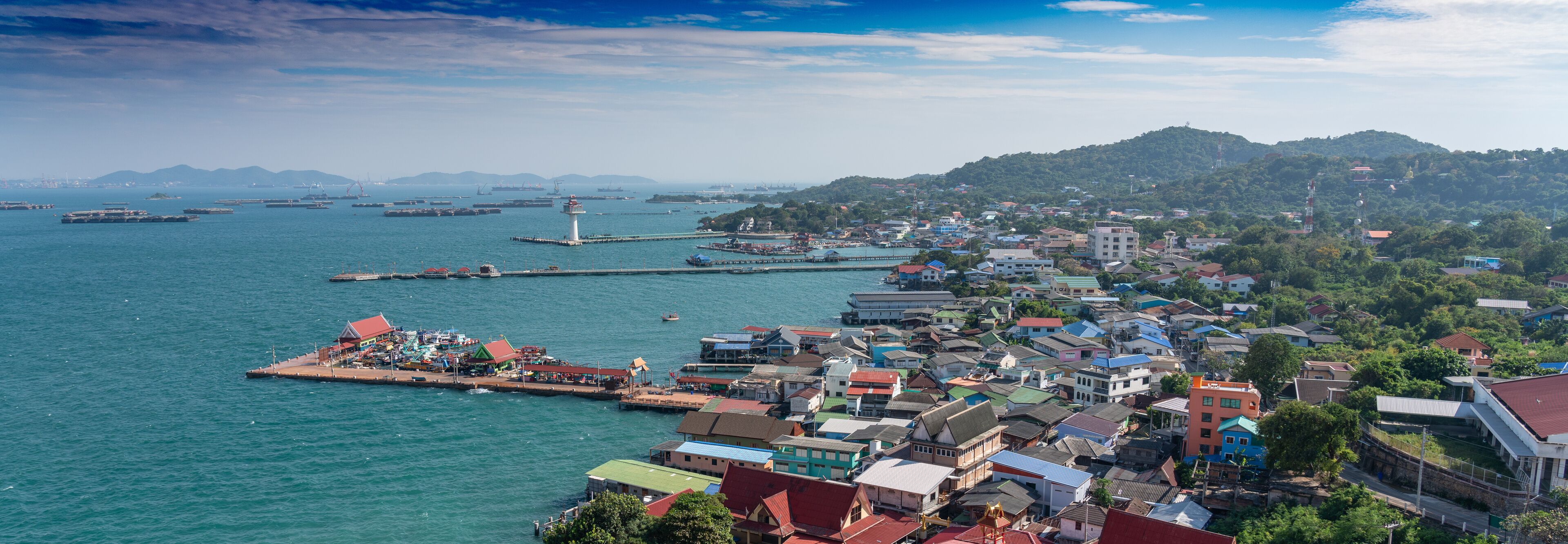 A coastal town with a harbor, boats, and a lighthouse.