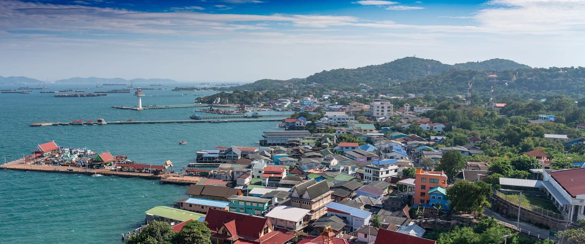 A coastal town with a harbor, boats, and a lighthouse.