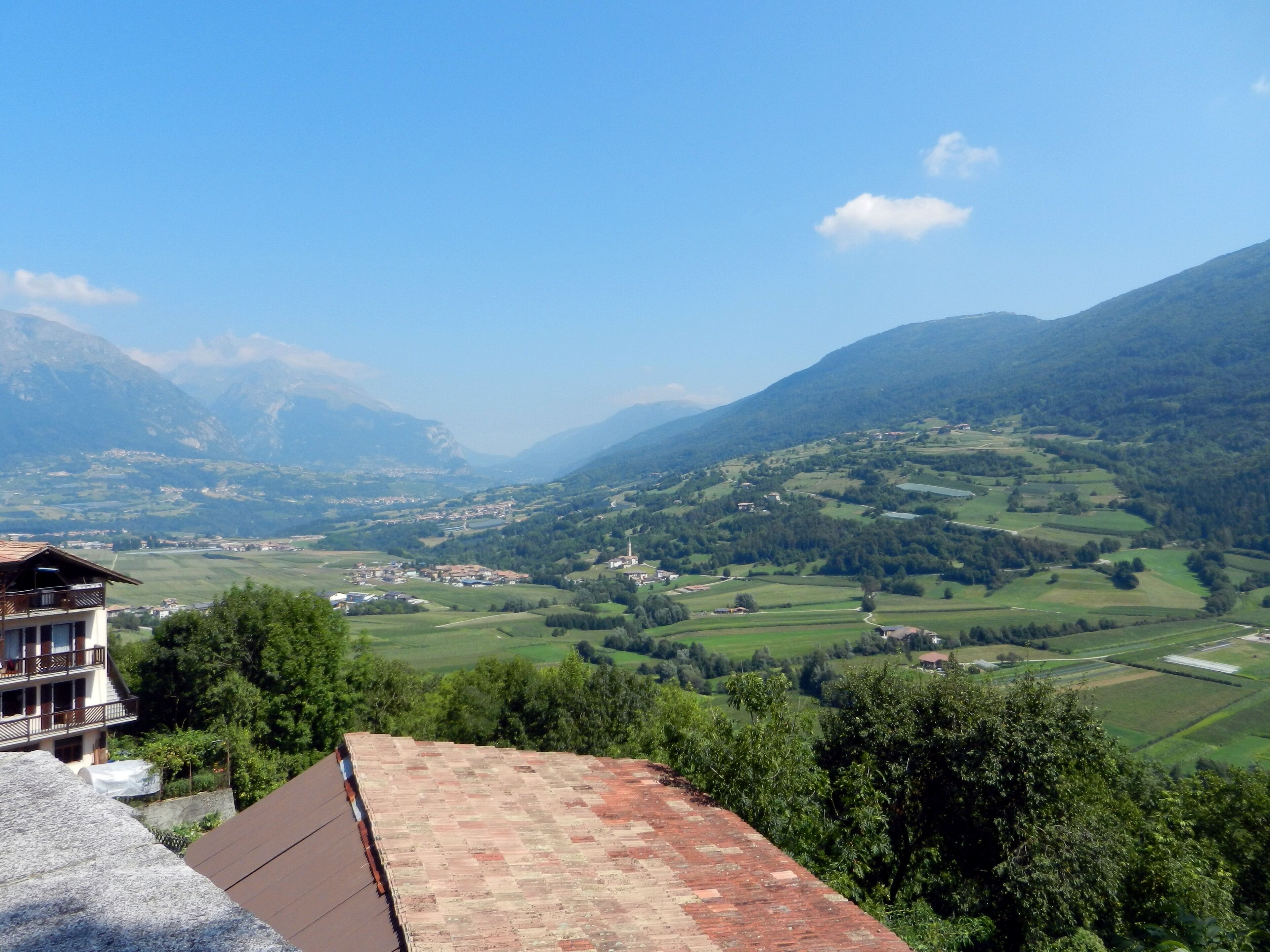 A mountainous landscape with a village and a house with a red roof.