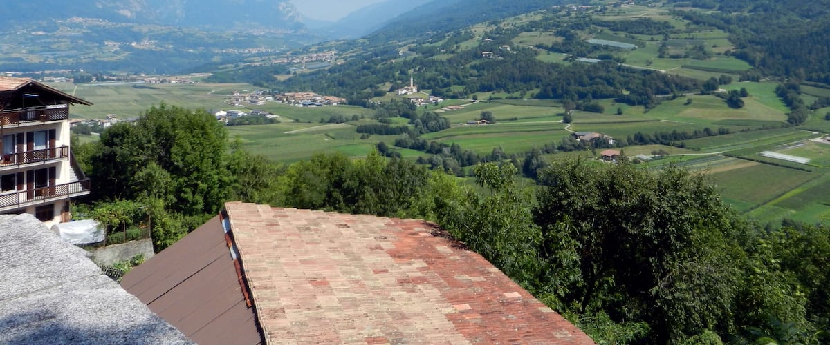 A mountainous landscape with a village and a house with a red roof.