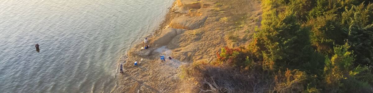 Top view people bank fishing along the sandy shore line at Ticky Creek Park, Lake Lavon, Texas, USA