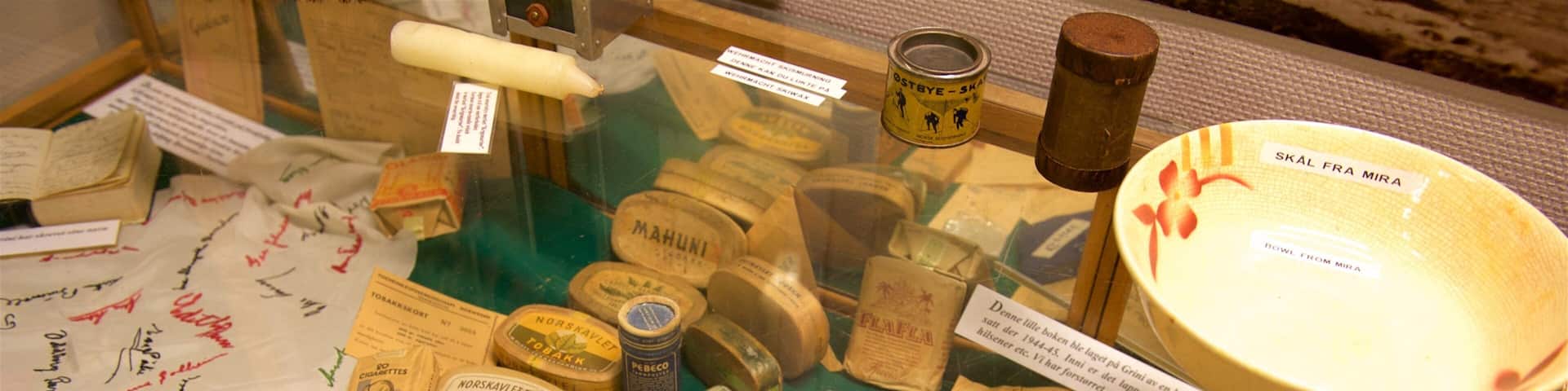 Una exhibición de objetos antiguos que incluye tabaco, postales y un zapato de papel llamado "Marina".