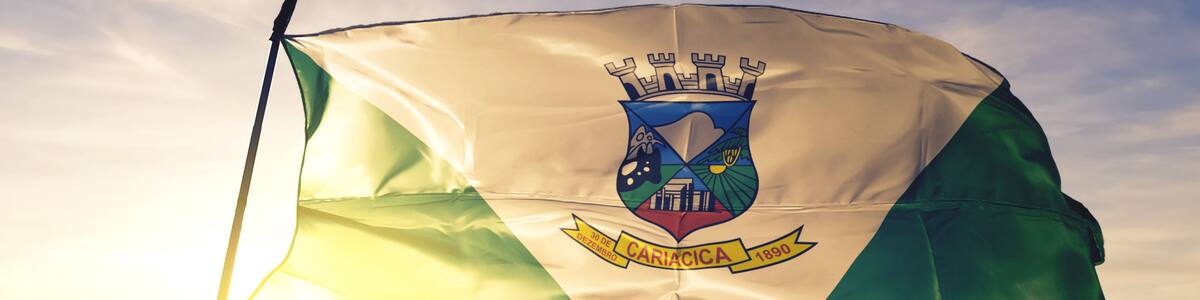 Cariacica of Brazil flag waving on the top sunrise mist fog