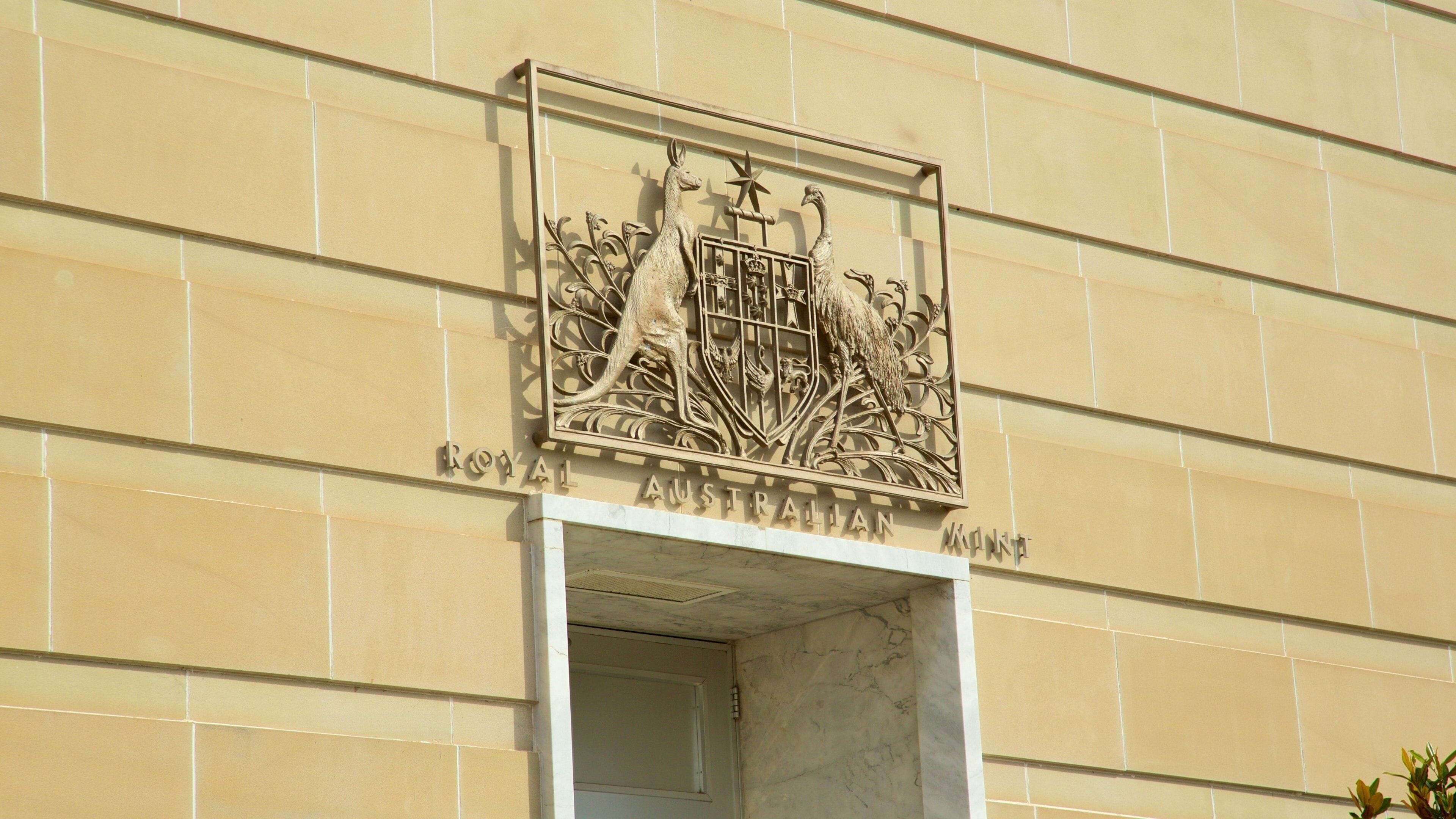 A building facade with a crest featuring a kangaroo, an emu, and a star.