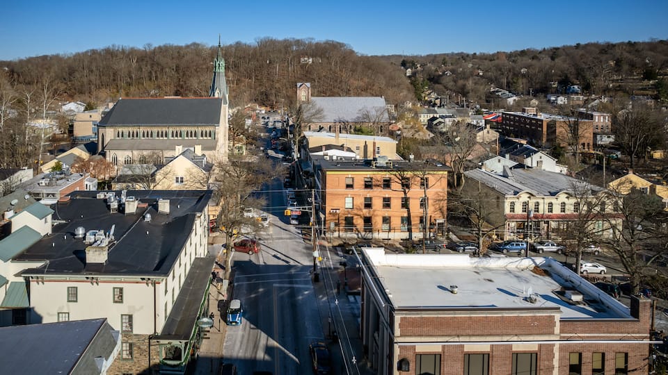 A town with a prominent church, a red brick building, and a green-roofed building.