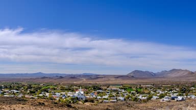 Uma pequena cidade aninhada em uma paisagem desértica, com montanhas ao fundo.