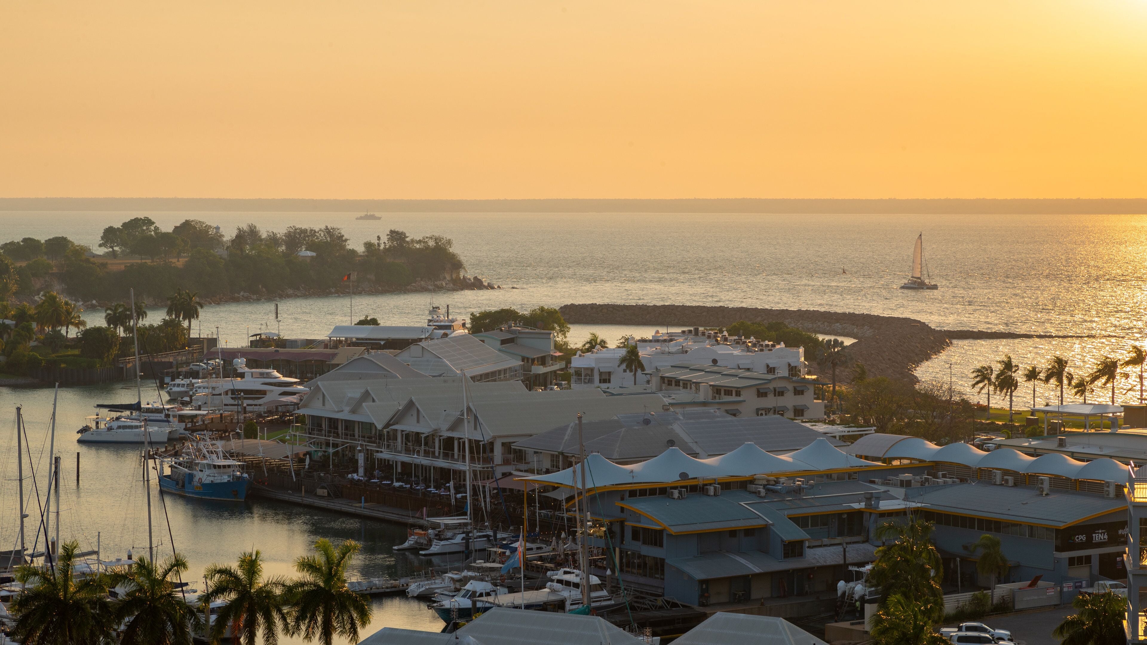 Cullen Bay Marina featuring a coastal town, landscape views and a sunset