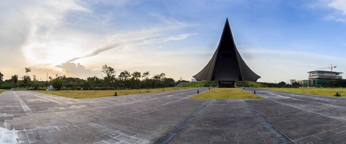 A large, modern pyramid-shaped monument with a wide, paved plaza in front.