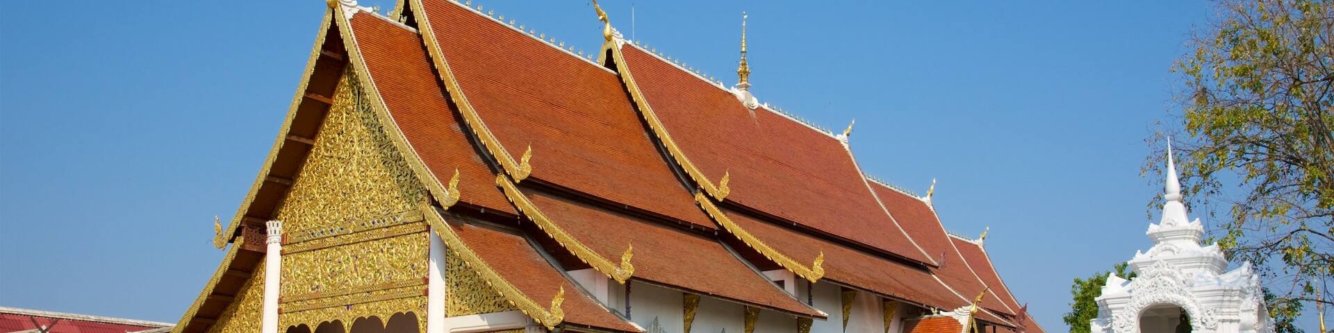 A traditional Thai temple with ornate golden decorations and a red roof.
