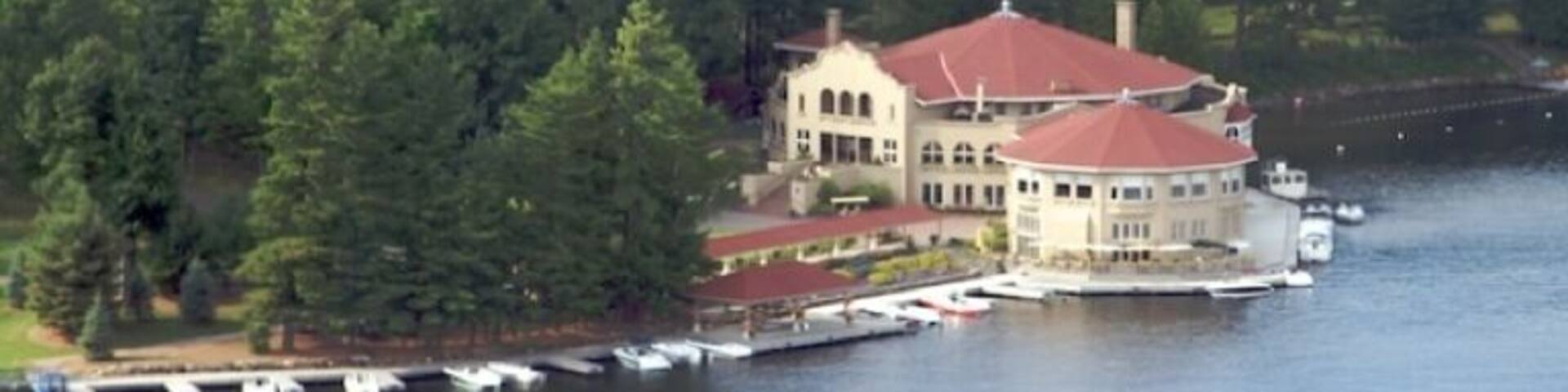 A lakeside property with a large house surrounded by dense forest.