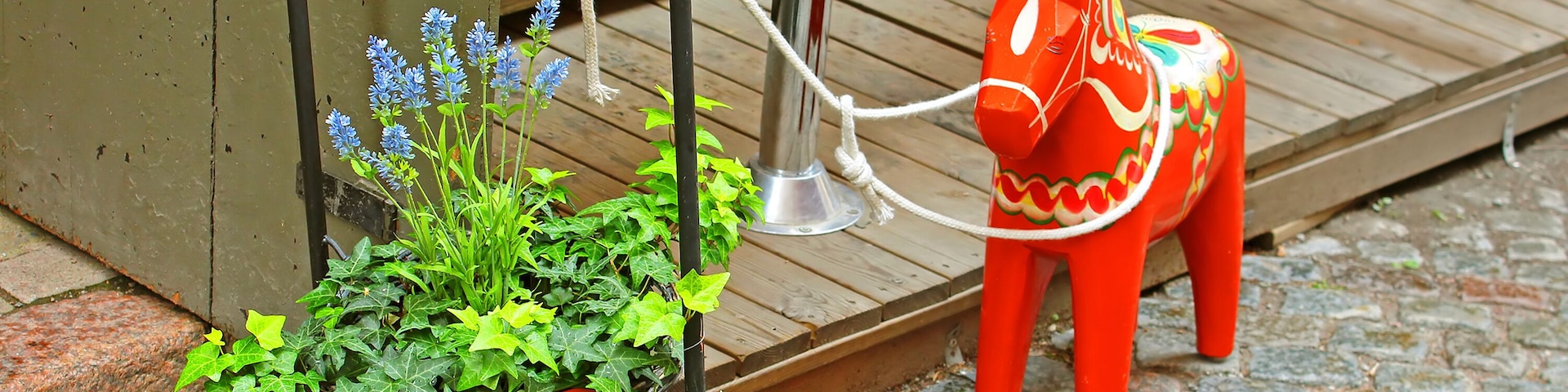 Inscription "Welcome" and a hand-made traditional wooden Dalecarlian Horse at the entrance to the little shop in Gamla Stan, Stockholm, Sweden