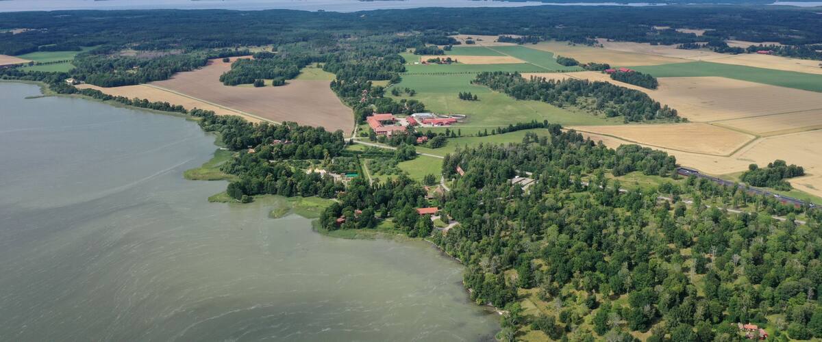A coastal landscape with a lake, forested areas, and agricultural fields.