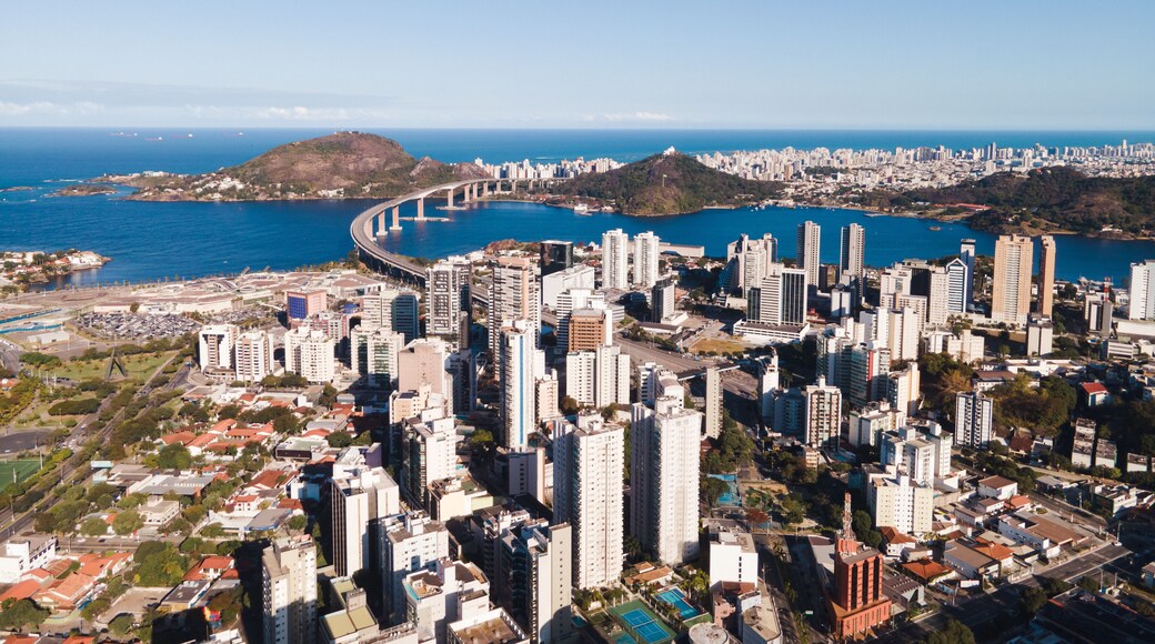 Imagem aérea da cidade de Vitória, mostrando a ponte, o centro, a Reta da Penha, Enseada do Suá, Bahia de Vitória e o Shopping Vitória.