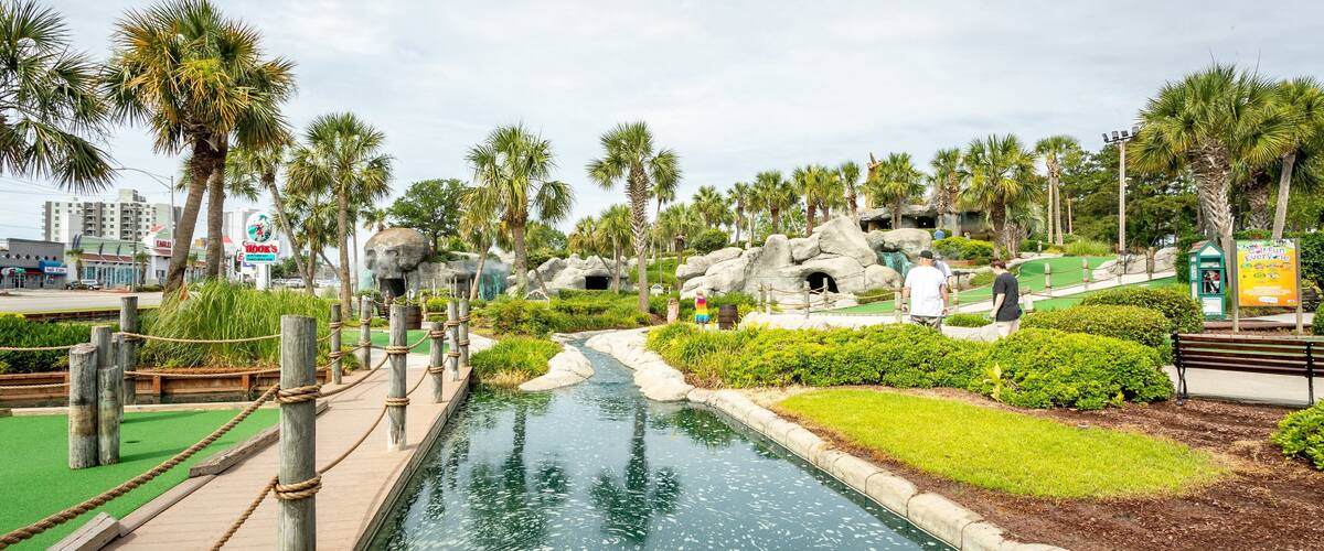 Captain Hook\'s Adventure Golf showing golf and a pond as well as a couple