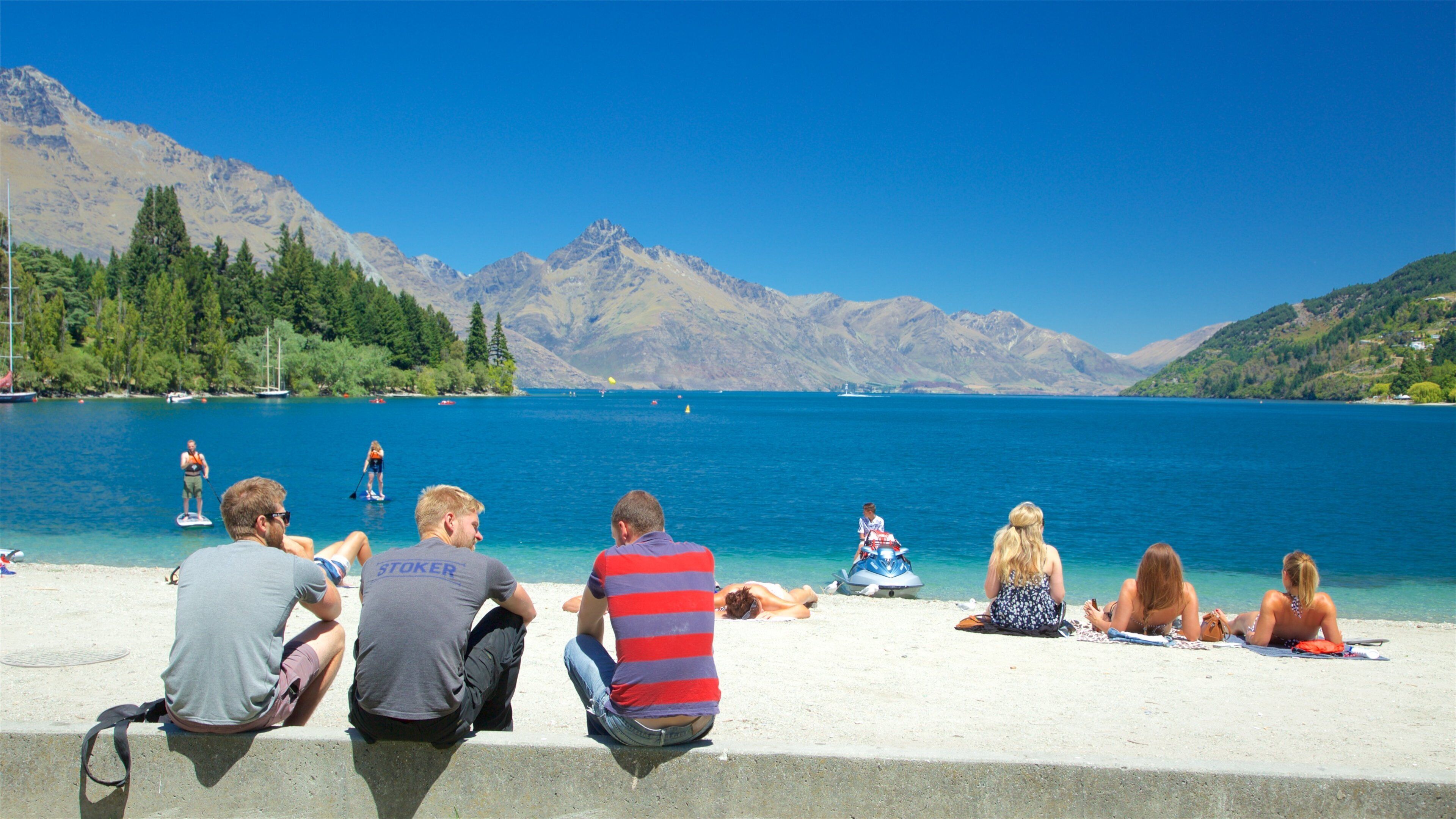 Queenstown City Centre showing general coastal views and a beach as well as a small group of people