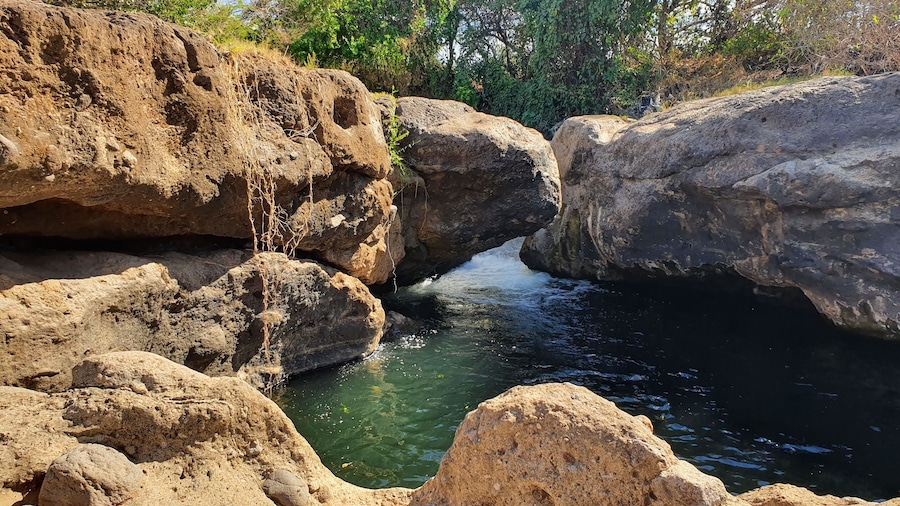 Un paisaje rocoso con un estrecho canal de agua que atraviesa una formación rocosa natural.