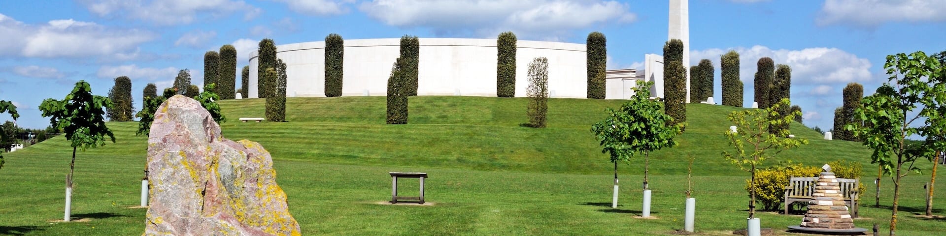 View of the Armed Forces Memorial with a large rock in the foreground, National Memorial Arboretum, Alrewas, UK.