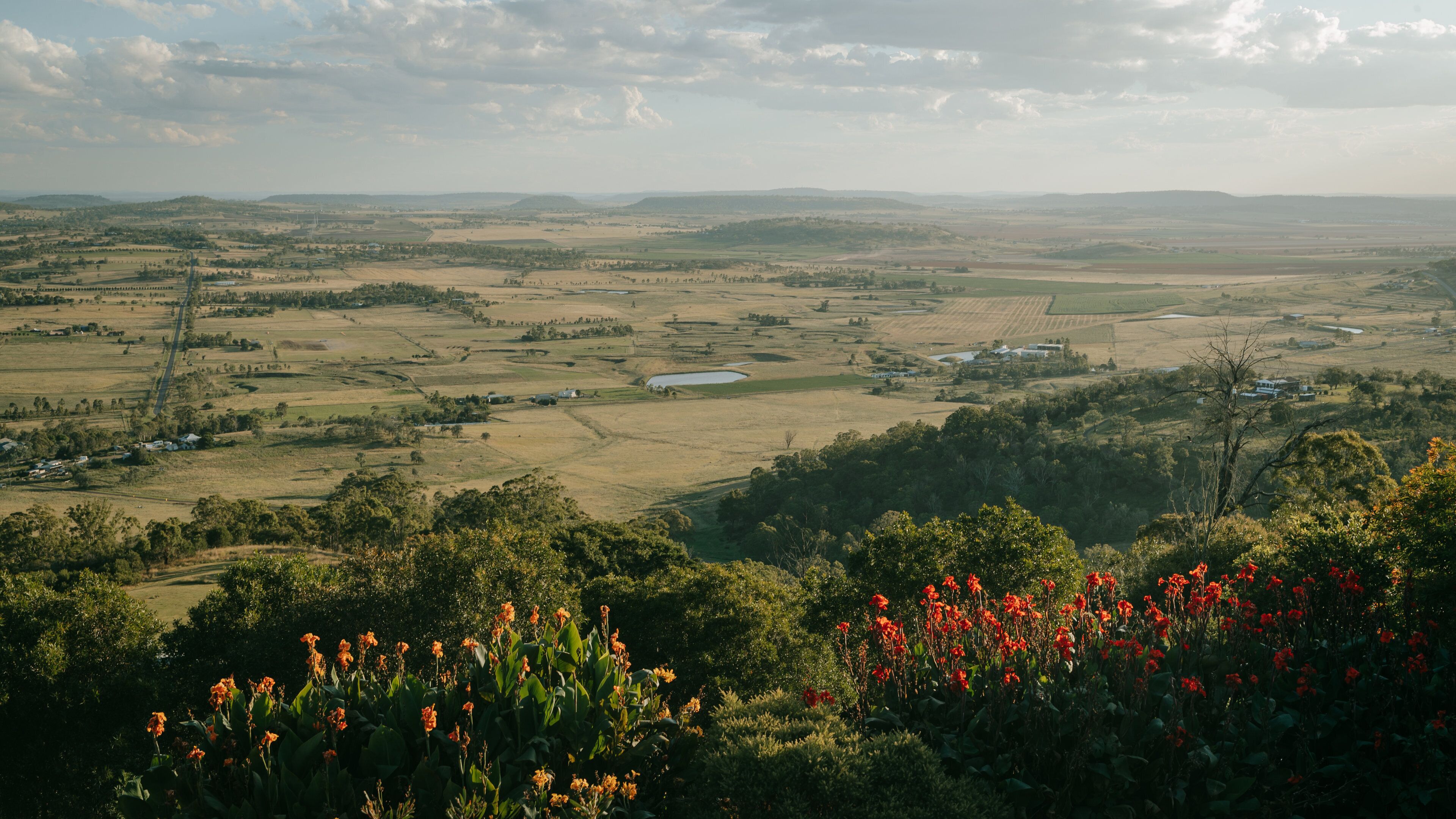 A rural landscape with fields, a lake, and scattered houses.