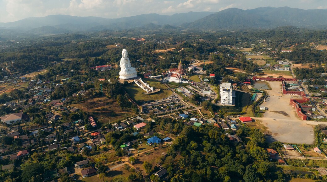 Aerial view of the serene Guan Yin statue standing tall amidst the tranquil landscape, a spiritual beacon under the vast sky, Tambon Ban Du, Chang Wat Chiang Rai, Thailand.
