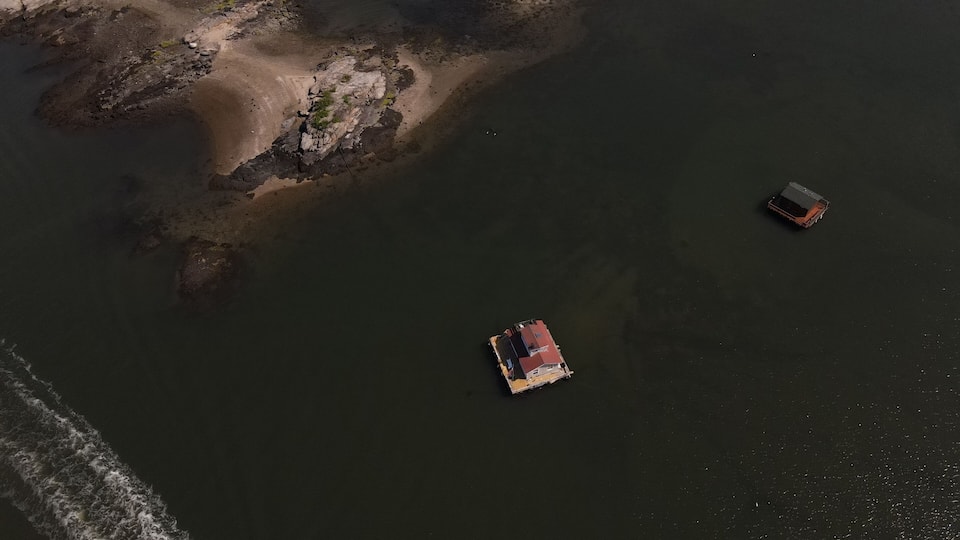 A river with a rocky shoreline and two boats.